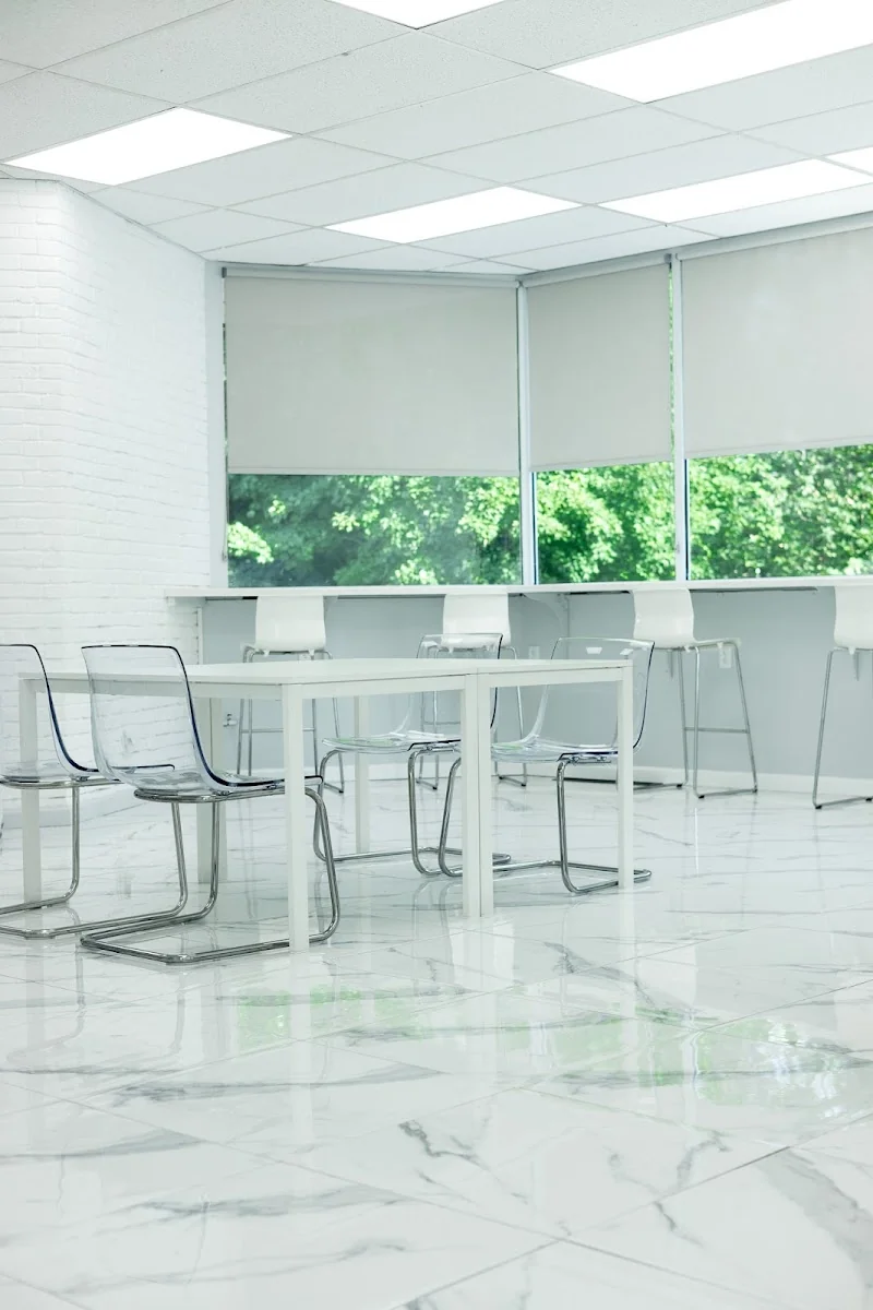 The Collective Space Windsor - minimalist white space with marble floors and clear acrylic chairs