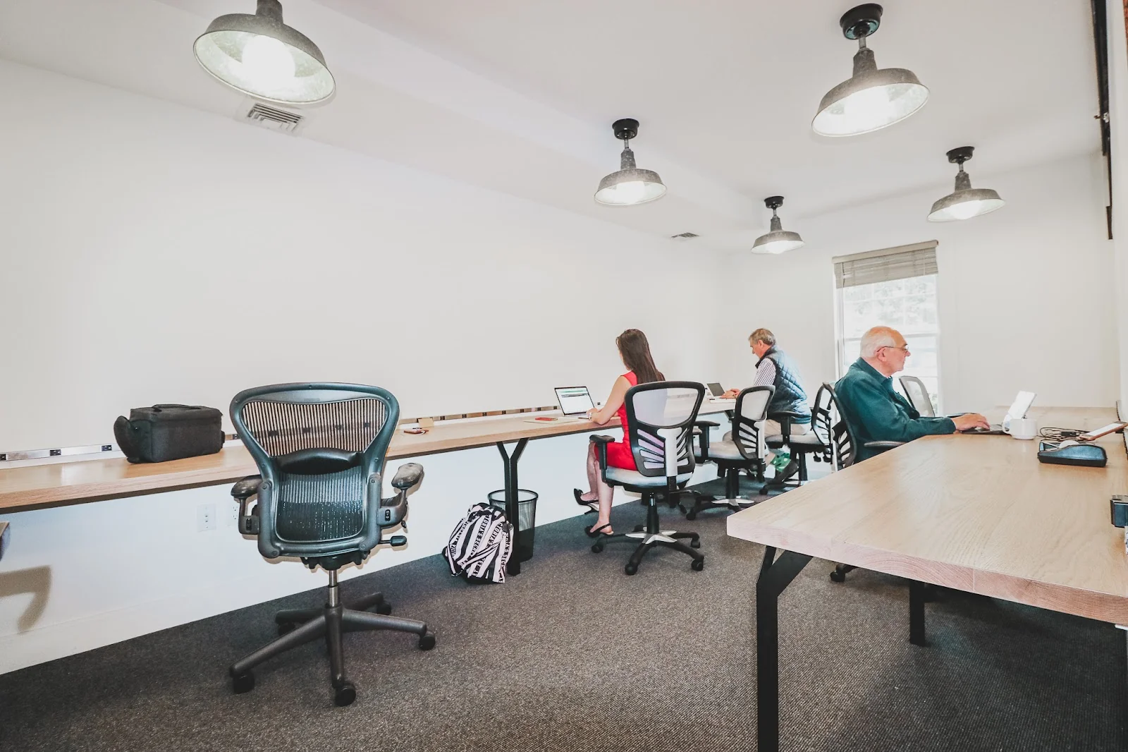 YARDwork co-working Litchfield - shared workspace with industrial lights and professionals at long desks