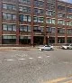 Cultivation Dallas exterior showing a multi-story red brick industrial warehouse building with large grid windows, street-level view on an overcast day