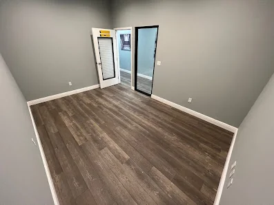 Easy Work Space private office room with dark hardwood floors, gray walls, and glass door entrance