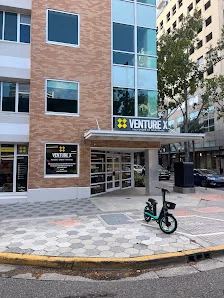 Venture X Downtown Orlando street-level exterior with yellow building and Venture X signage