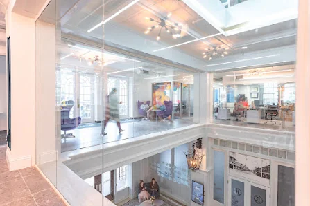 Expansive Angebilt Building stunning two-story glass atrium interior with sputnik chandeliers and classical white architecture