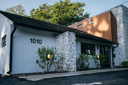 Suite Spaces Orlando charming renovated building at address 1010 with stone pillar entrance and wood-paneled upper facade