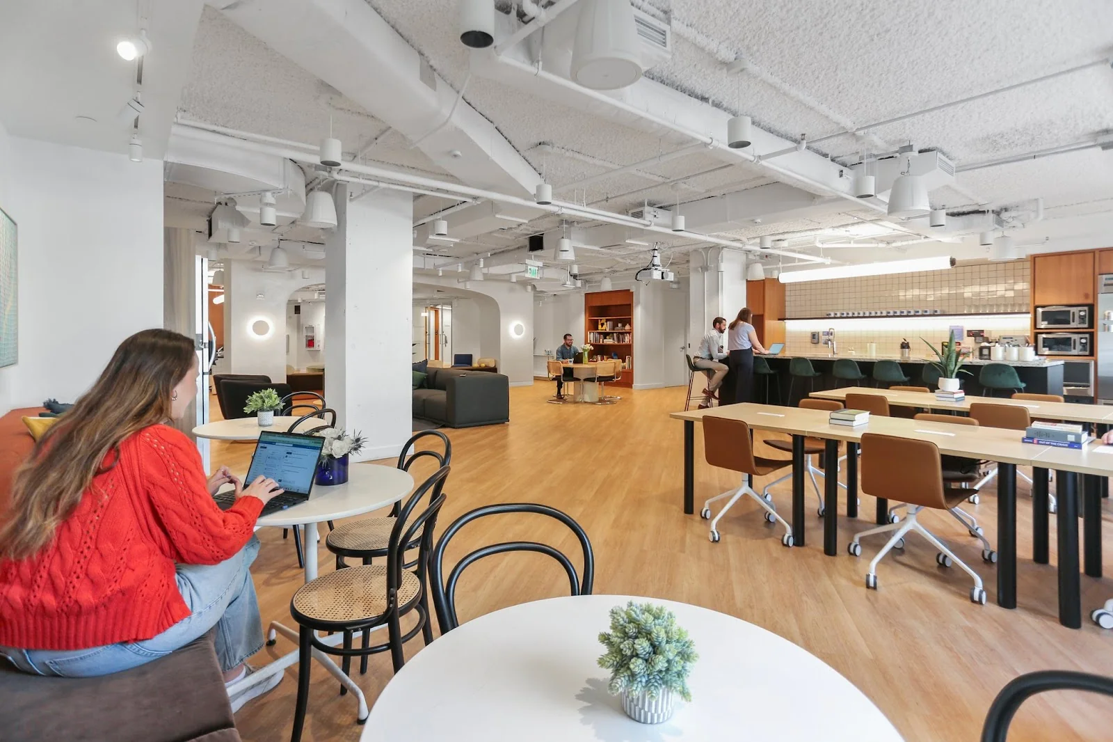 Workbox Dupont Circle open workspace with warm wood tones, kitchen area, and people working at communal tables